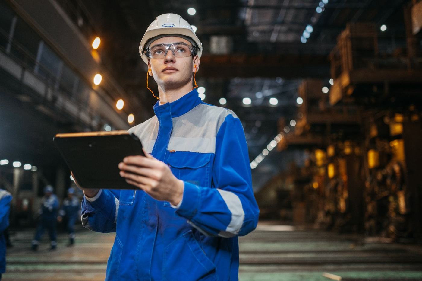 Engineer with a tablet in a production hall — service records and staff training